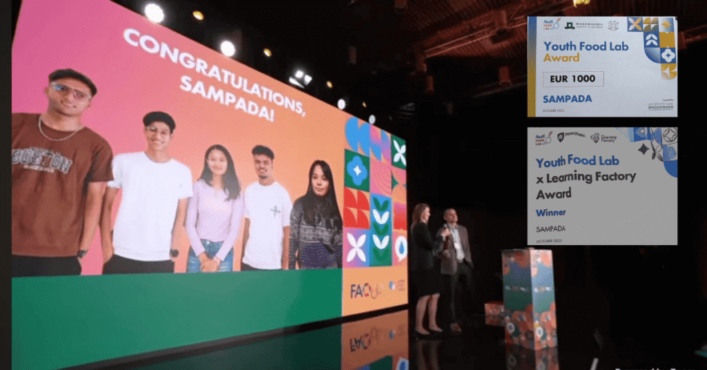 A group of five young people from Nepal's Team Sampada are shown virtually on a large screen with the words "CONGRATULATIONS, SAMPADA!". In the foreground, two award certificates are visible: one for the "Youth Food Lab Award (EUR 1000)" and one for the "Youth Food Lab x Learning Factory Award," both recognizing SAMPADA.